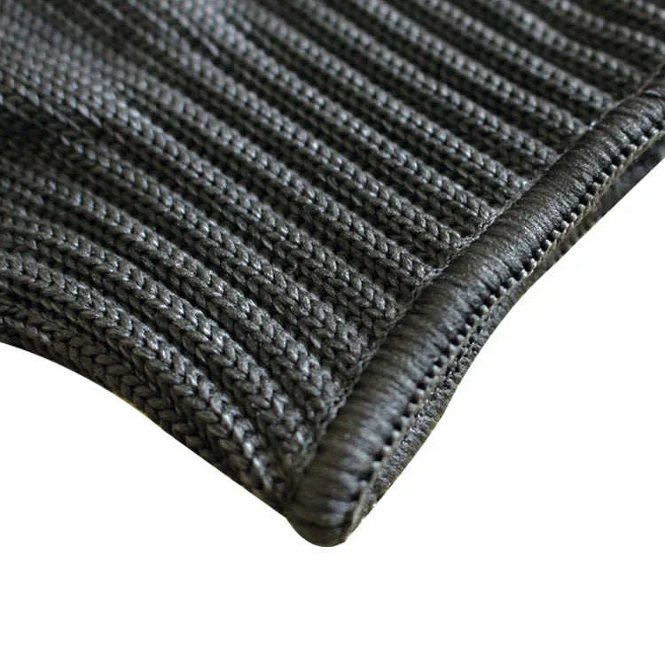 Close-up of the knitted texture and stitched edge of a black safety glove